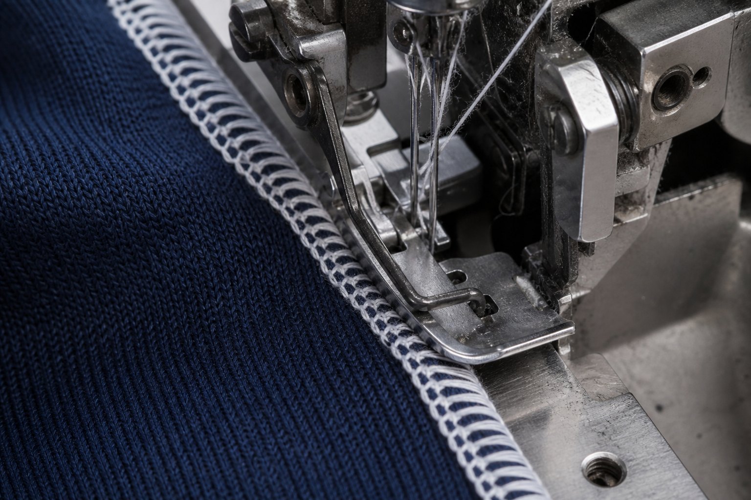 Referência visual de overlock industrial em malha azul-marinho. Imagem ilustrativa.